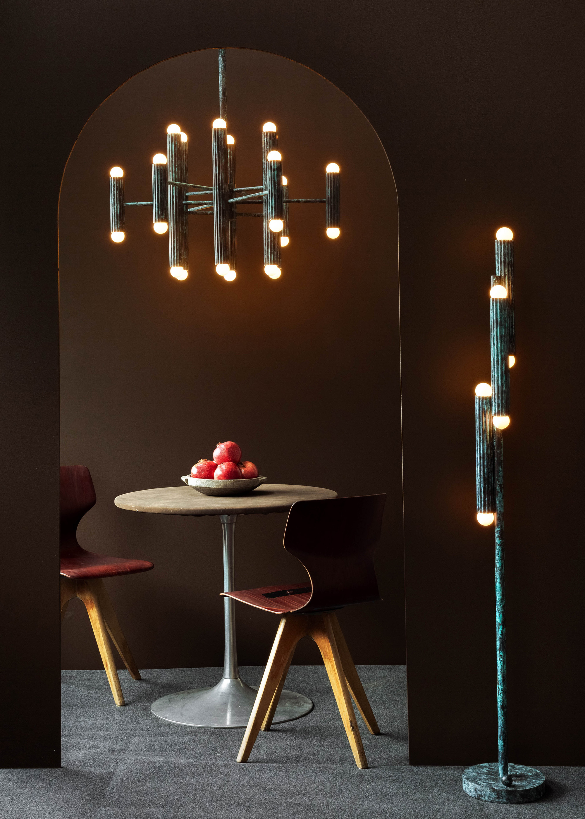 Vesta brass and glass chandelier with matching wall sconce and floor lamp in a refined dining interior by Schwung.