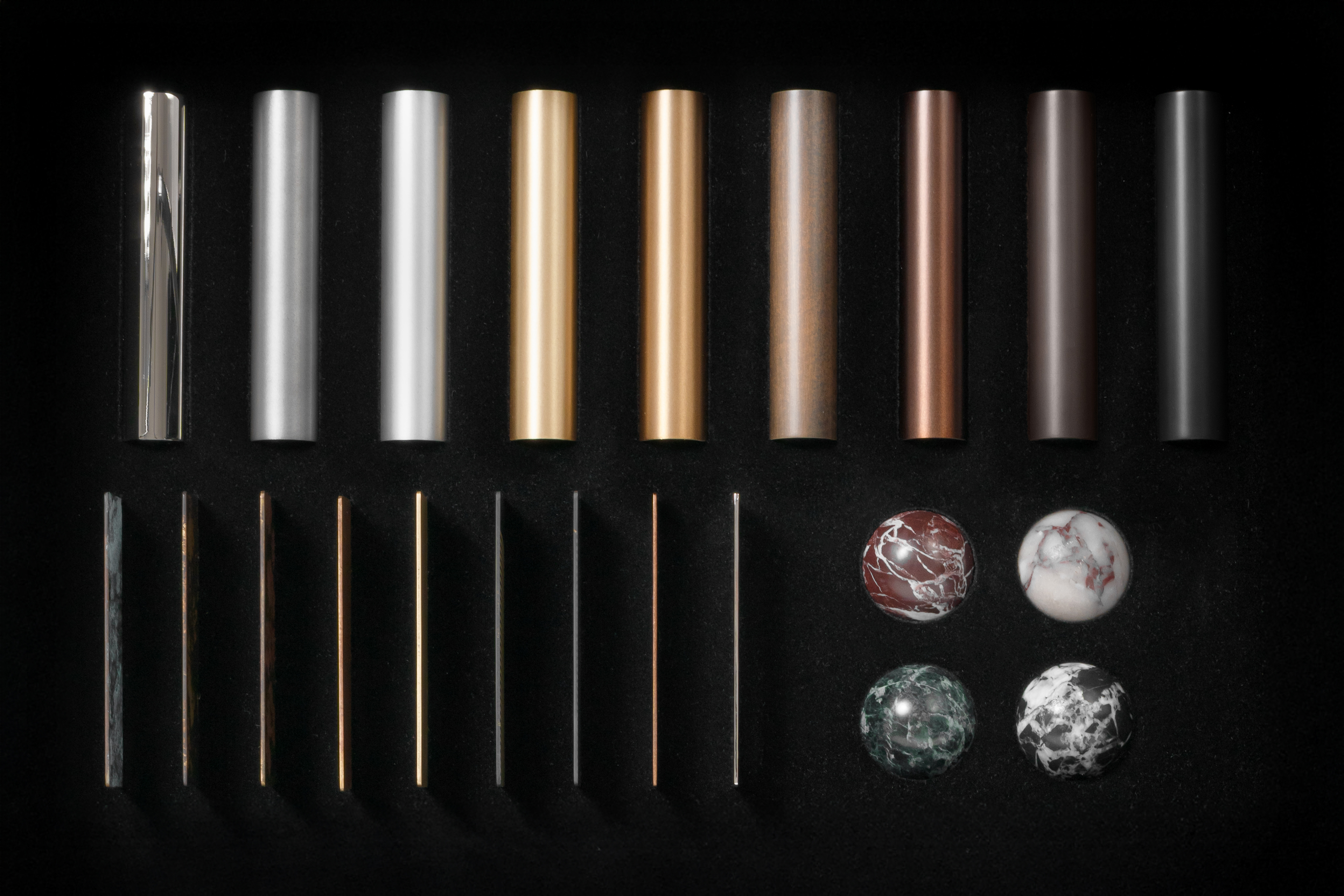 Schwung Finish Sample Box featuring marble spheres, brass finish tubes and 10 × 10 cm finish plates for handcrafted lighting projects.