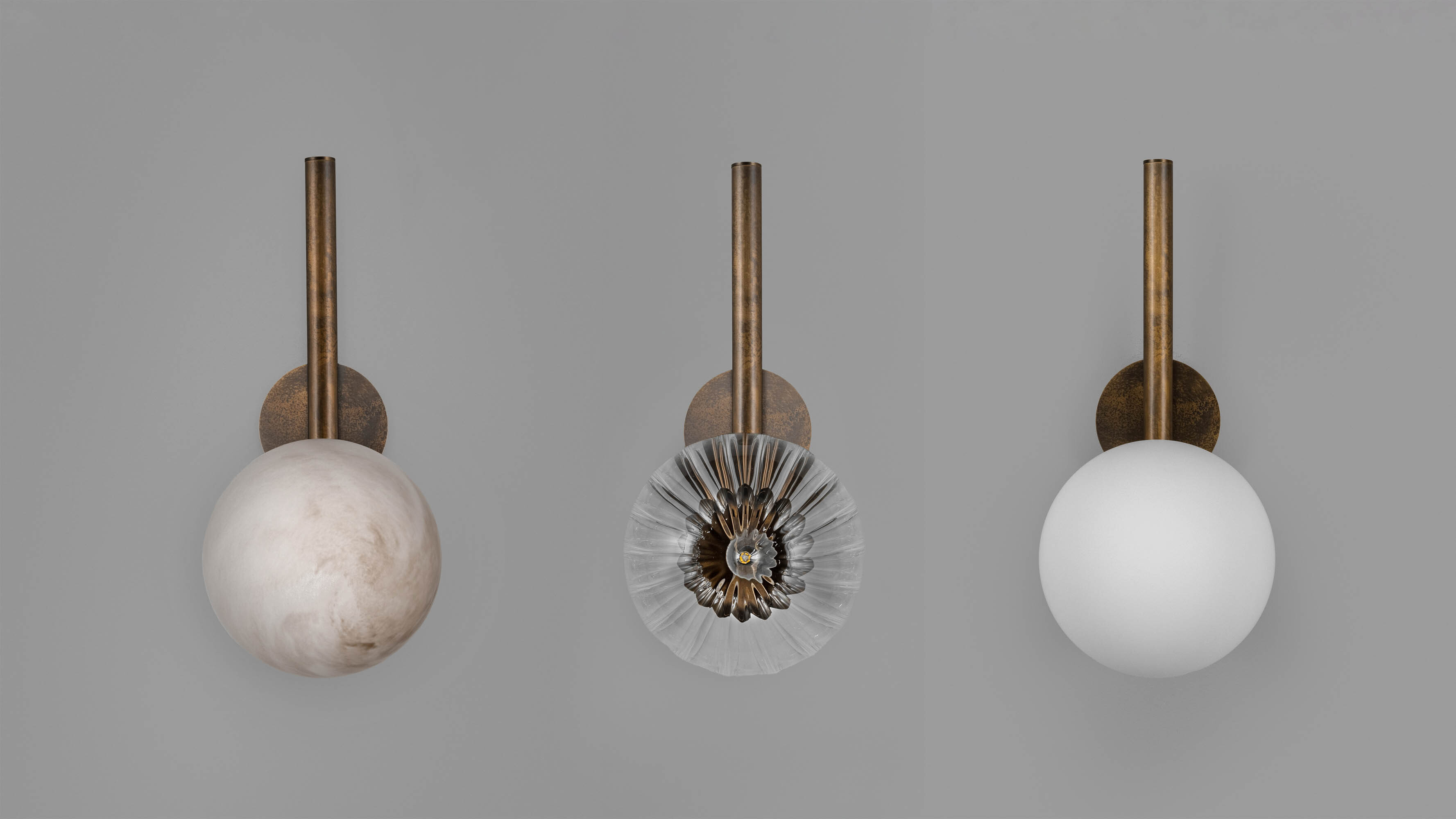 Three Tubular MD brass and glass wall sconces in a Classic Bronze finish, handcrafted by Schwung, showcasing Opal Matte, Dries wavy glass and Marble glass shade options available in the collection.