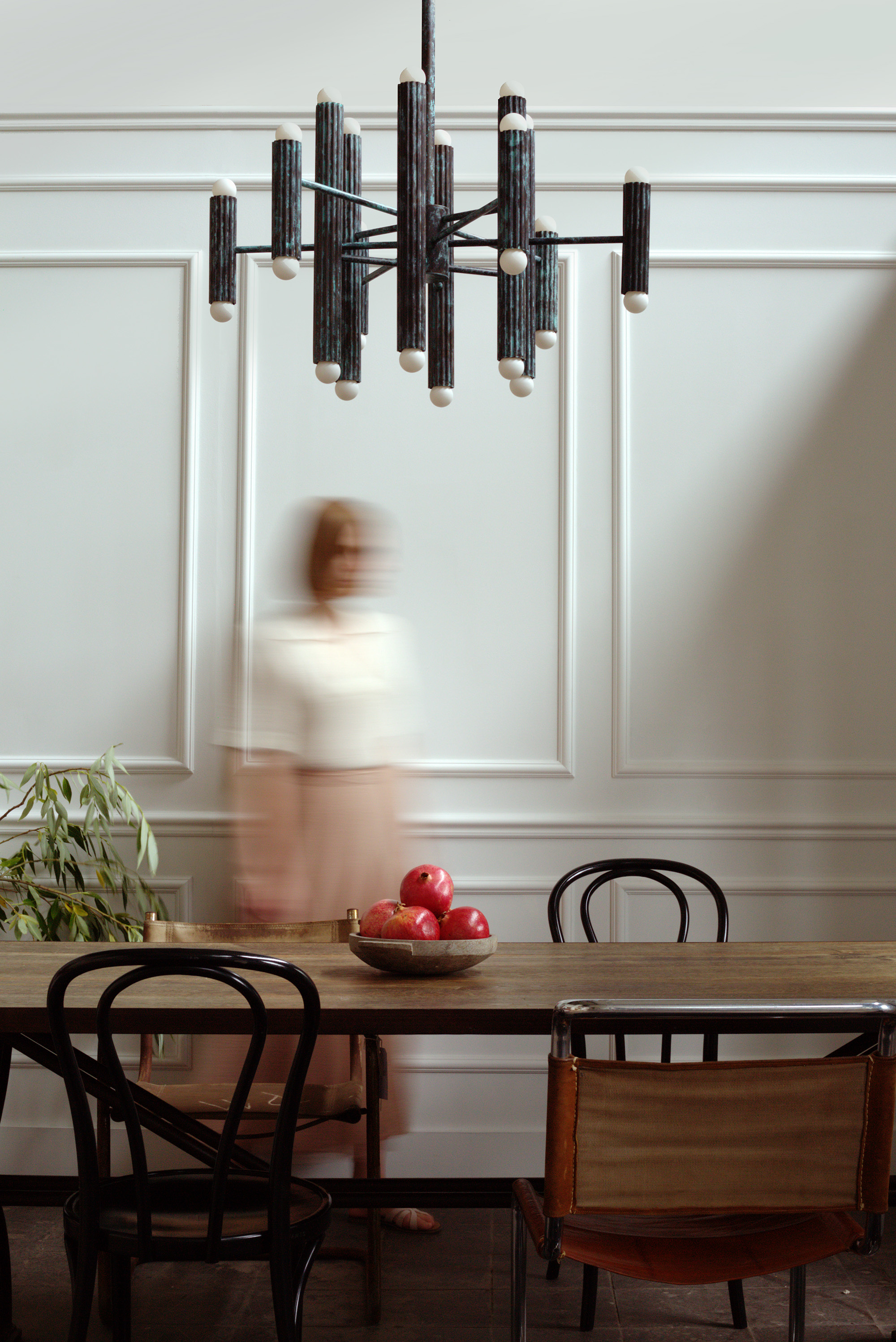 Vesta brass and glass chandelier above a refined dining table in a bright classic interior by Schwung.