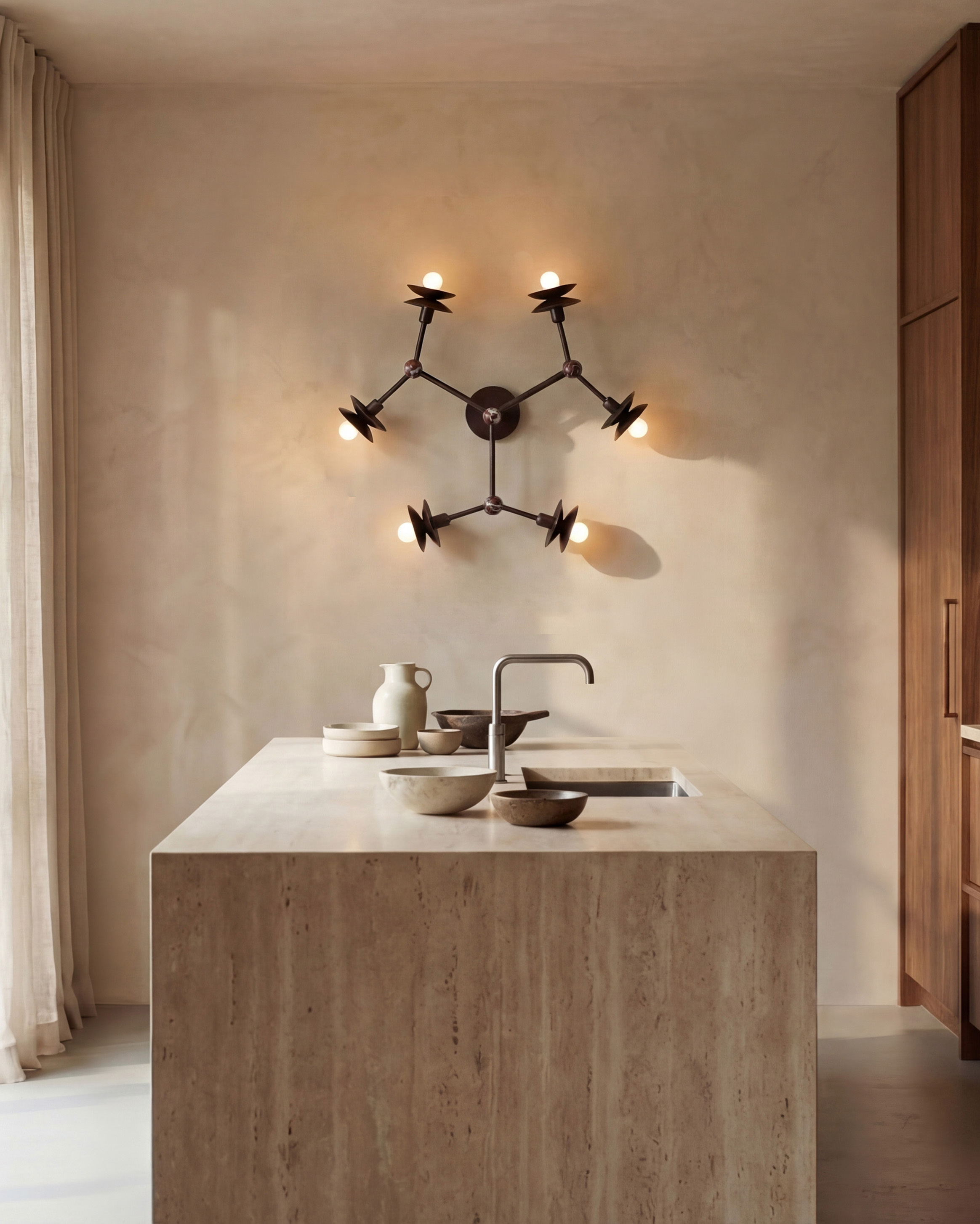Babylon 6 brass and marble wall sconce/flush mount in a Classic Bronze finish, handcrafted by Schwung, installed on a kitchen wall.