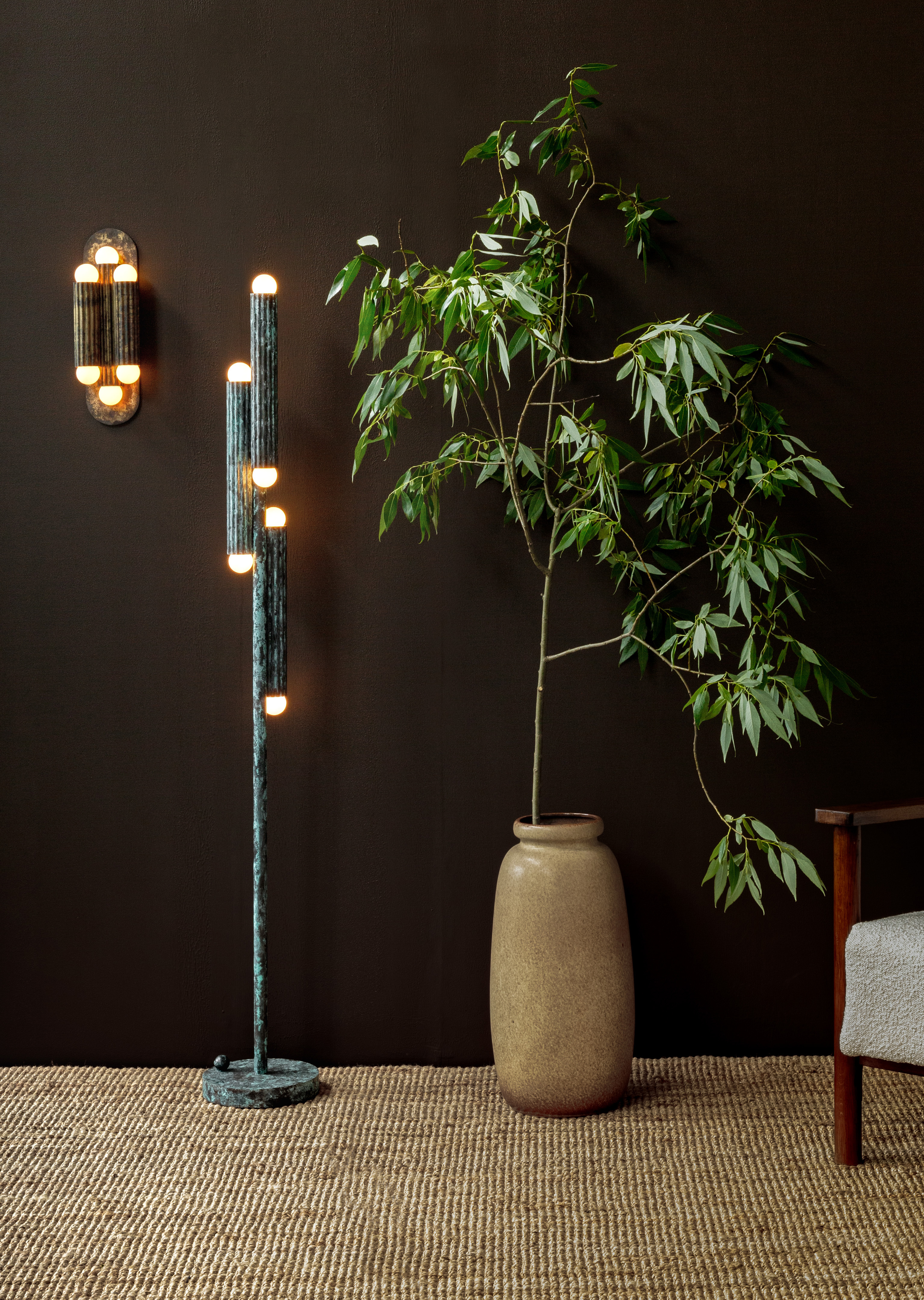 Vesta Floor lamp and Vesta Triple wall sconce in an elegant, softly lit interior with sculptural greenery by Schwung.