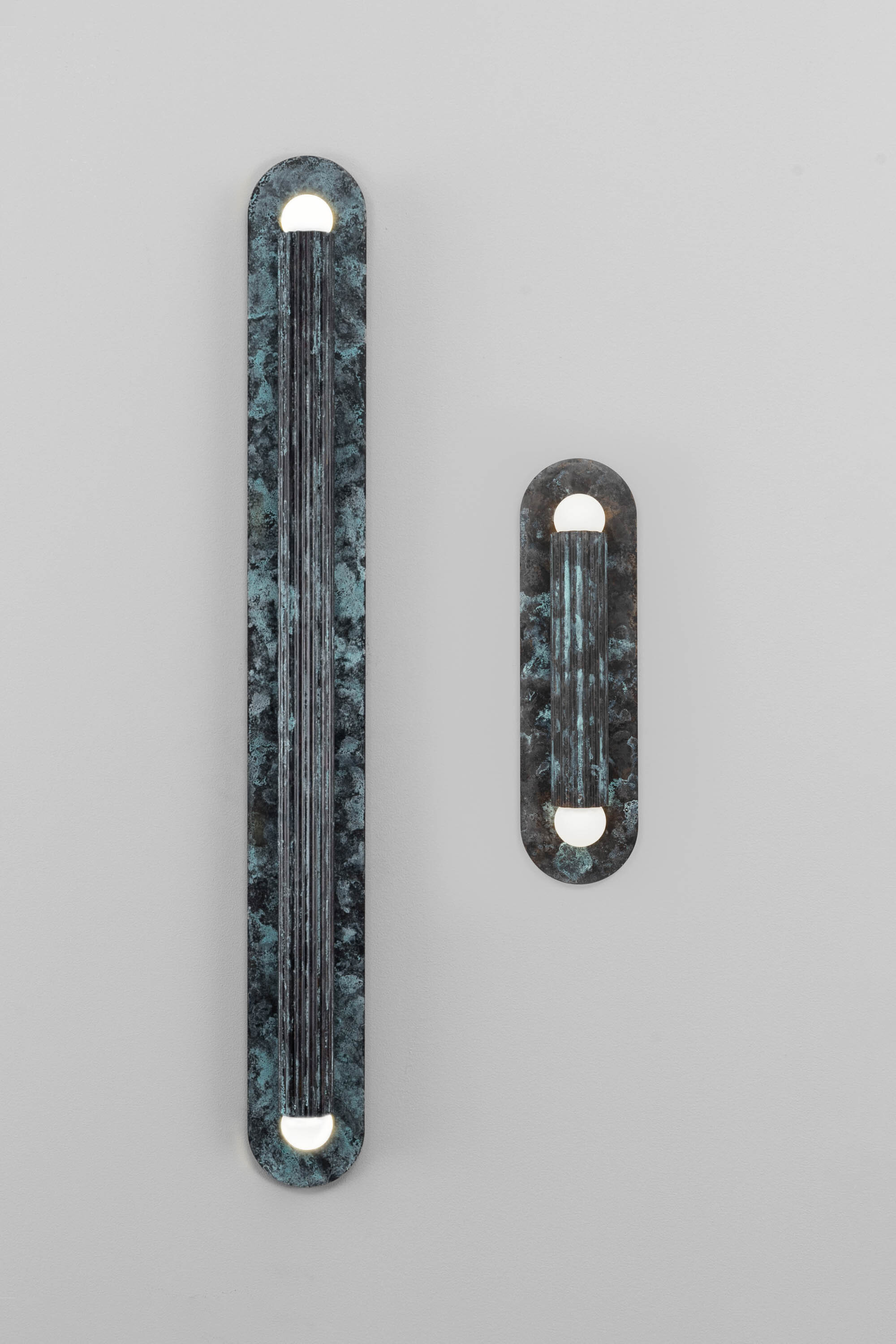 Vesta XLG and Vesta MD wall sconces in verdigris ash finish, handcrafted by Schwung.