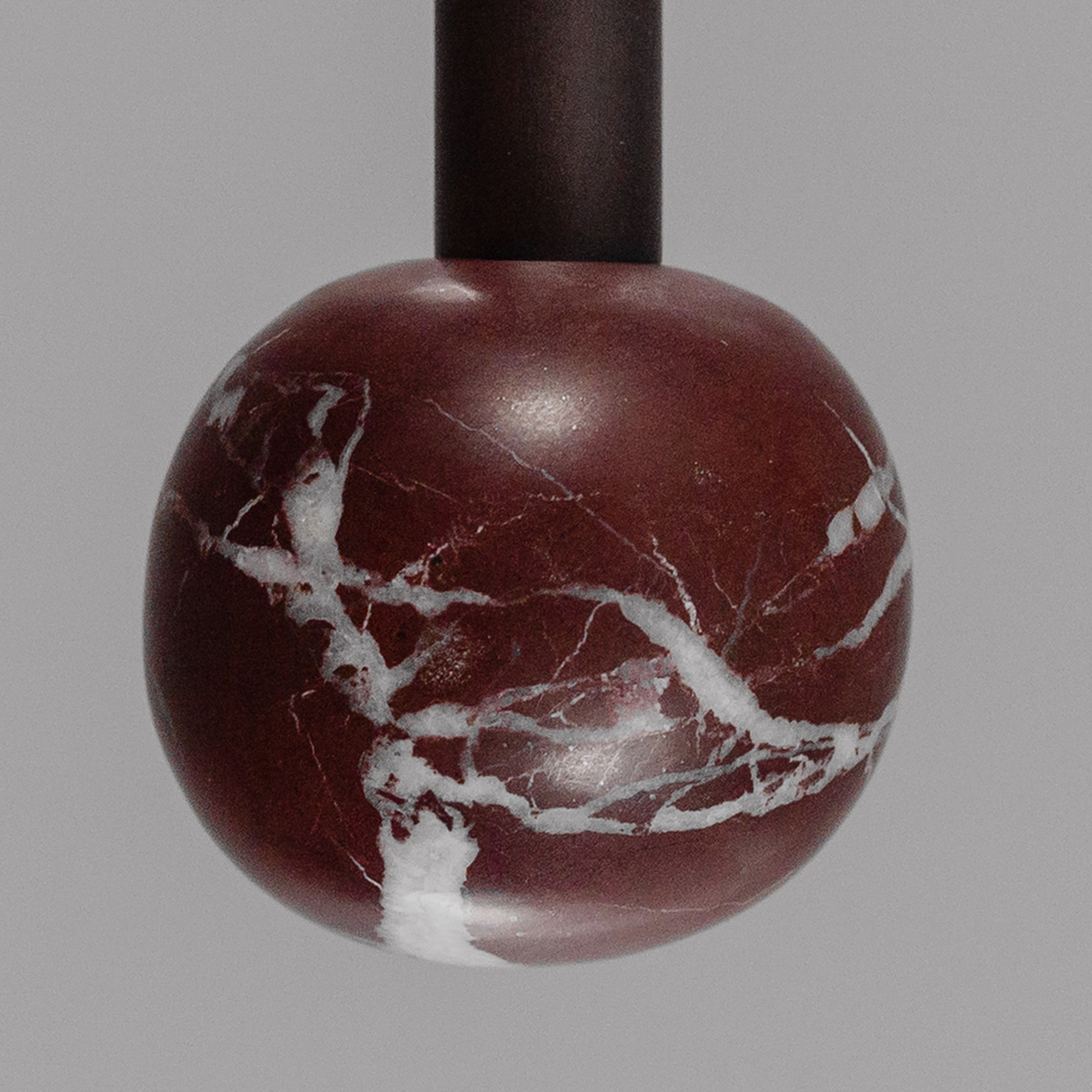 Rosso Levanto marble ball. Close-up detail of the Babylon Double brass and marble wall sconce in a Classic Bronze finish, handcrafted by Schwung.