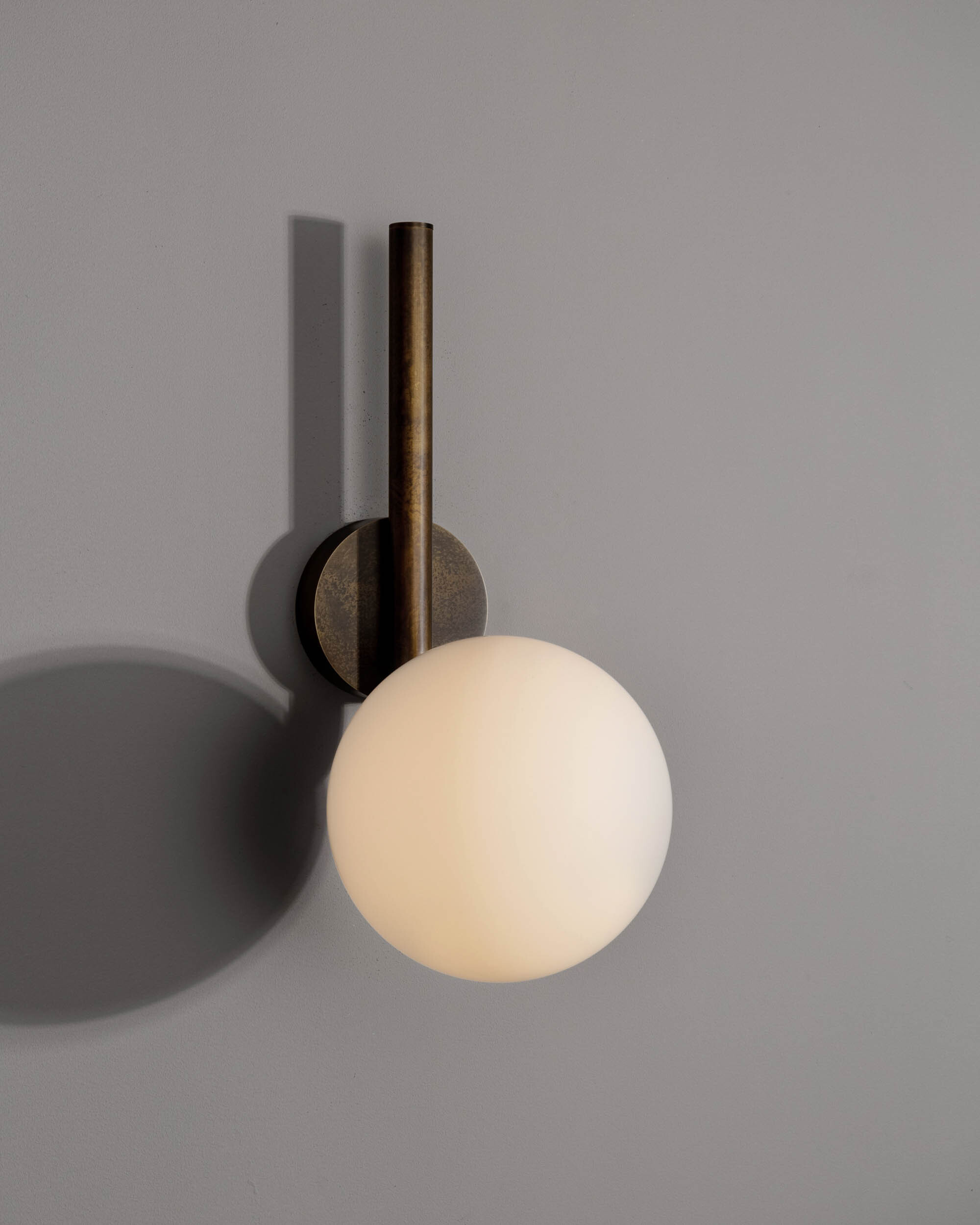 Tubular MD brass and glass wall sconce in a Classic Bronze finish with an Opal Matte glass shade, handcrafted by Schwung.